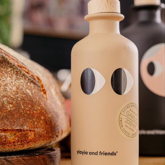 Loaf of bread on a wooden board with a beige bottle featuring black circular designs.