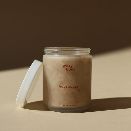 Jar of Wiley Body body scrub on a beige surface with a brown background