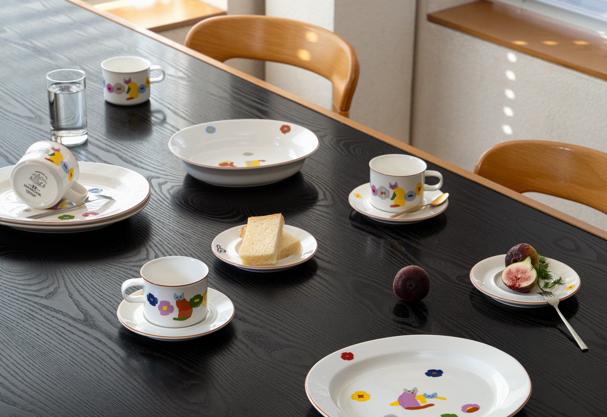 Set of ceramic tea cups and saucers with decorative patterns on a black table.