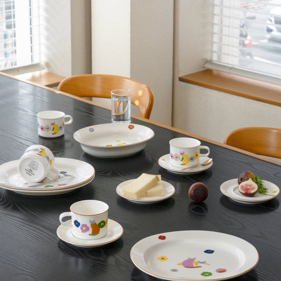 Dishes with patterns on a dining table with a glass of water and bread.