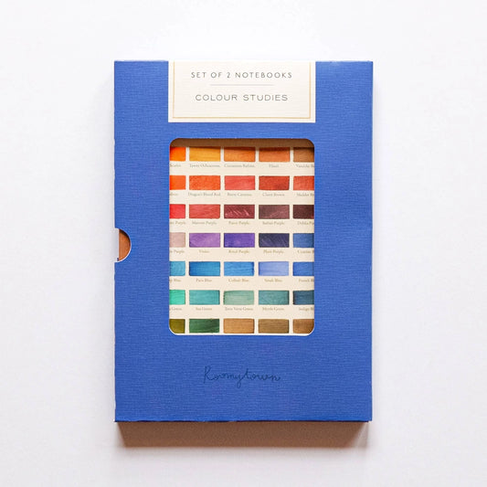 A set of two colour studies notebooks in a blue textured cover with a clear window showing multiple color swatches, photographed on a white background.